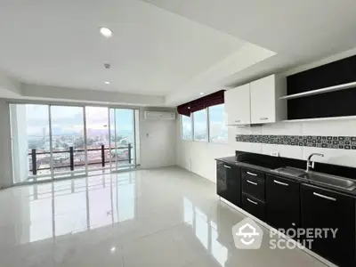 Spacious modern kitchen with open layout and stunning city view from balcony.