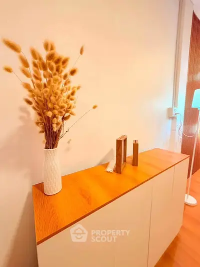 Stylish modern interior with elegant wooden cabinet and decorative vase, perfect for contemporary living spaces.