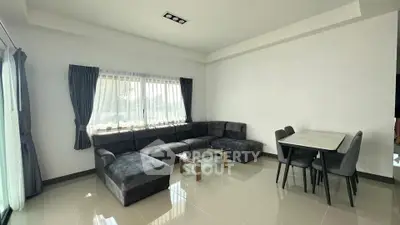 Spacious modern living room with large sectional sofa and dining area, featuring natural light and elegant decor.