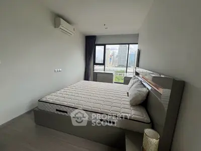 Spacious bedroom with city view, modern furnishings, and ample natural light.