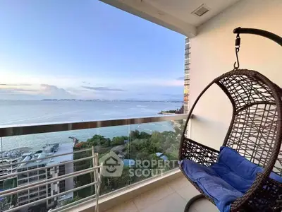 Stunning ocean view from a modern balcony with a cozy hanging chair, perfect for relaxation.