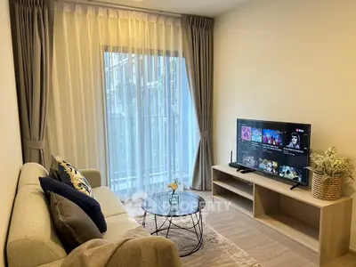 Cozy living room with modern decor and large window for natural light.