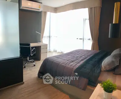Modern bedroom with sleek design and natural light, featuring a work desk and cozy bedding.