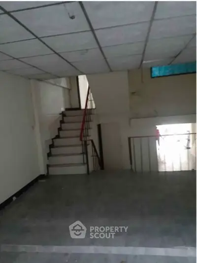 Spacious interior with staircase and tiled flooring, ideal for customization and renovation.