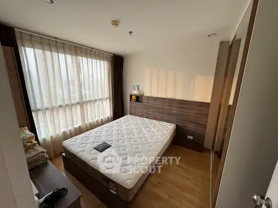 Bright and cozy bedroom with large window and modern furnishings