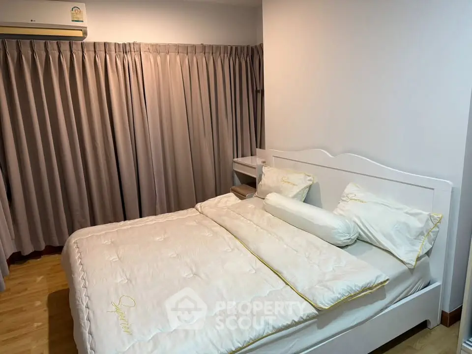 Cozy bedroom with elegant white bedding and soft lighting, perfect for relaxation and comfort.