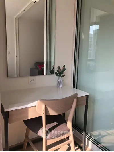Bright study nook with modern desk and chair by a large window, perfect for productivity.