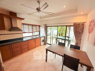 Spacious kitchen with open layout and dining area, featuring modern appliances and garden view.