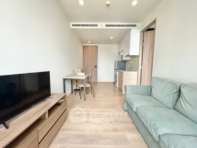 Modern living room with cozy sofa and sleek kitchen in open layout apartment.