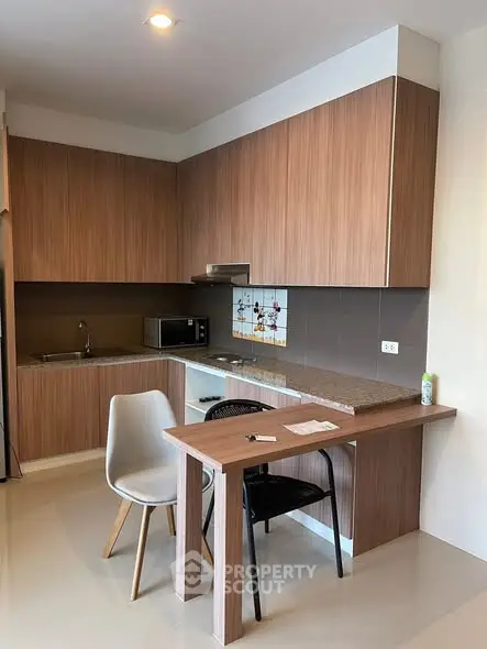 Modern kitchen with sleek wooden cabinets and compact dining area