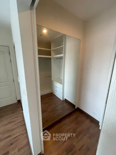 Spacious walk-in closet with wooden flooring and ample storage space