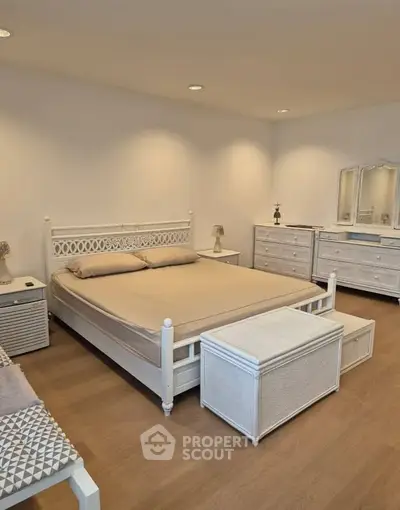 Spacious bedroom with elegant white furniture and cozy ambiance
