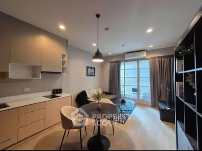 Modern living room with open kitchen, stylish decor, and balcony view in a contemporary apartment.