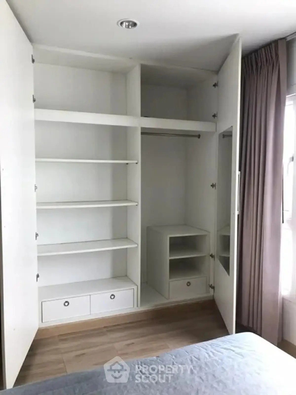 Spacious bedroom with built-in white wardrobe and natural light
