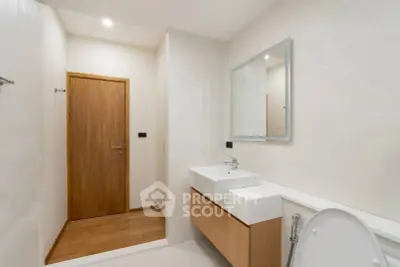 Modern minimalist bathroom with sleek fixtures and wooden accents.