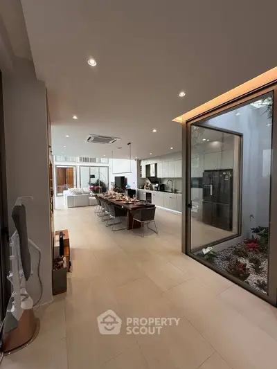 Luxurious open-plan living and dining area with modern kitchen and garden view