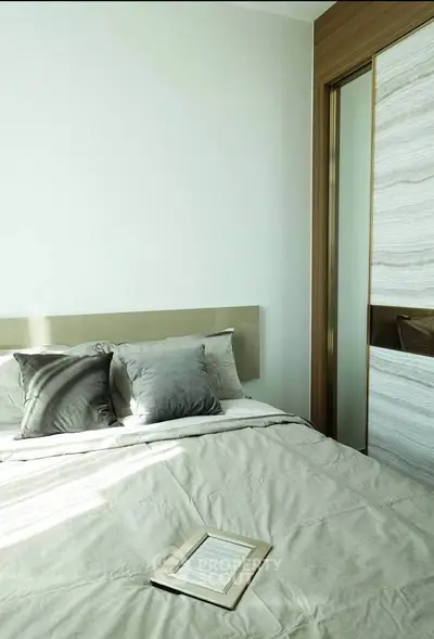 Modern bedroom with elegant decor and natural light, featuring a cozy bed and stylish pillows.
