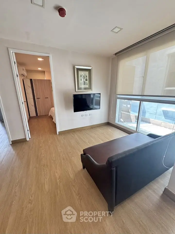 Modern living room with wooden flooring and large window view
