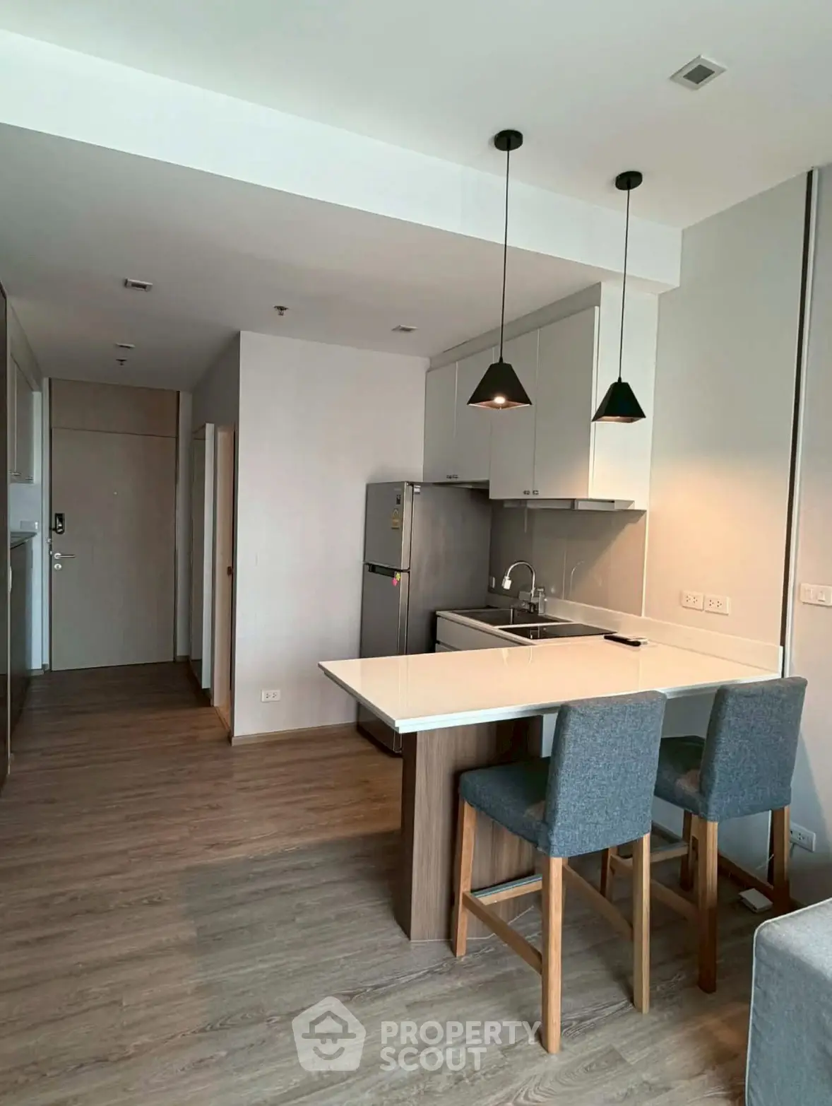 Modern kitchen with open layout and stylish lighting in a cozy apartment.