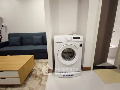 Modern apartment interior with washing machine and stylish living area.