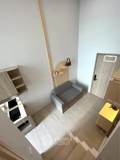 Modern loft-style living room with high ceiling and minimalist decor