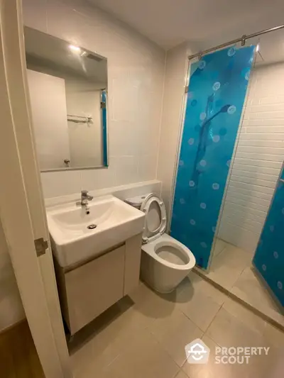 Modern bathroom with sleek fixtures and blue shower curtain