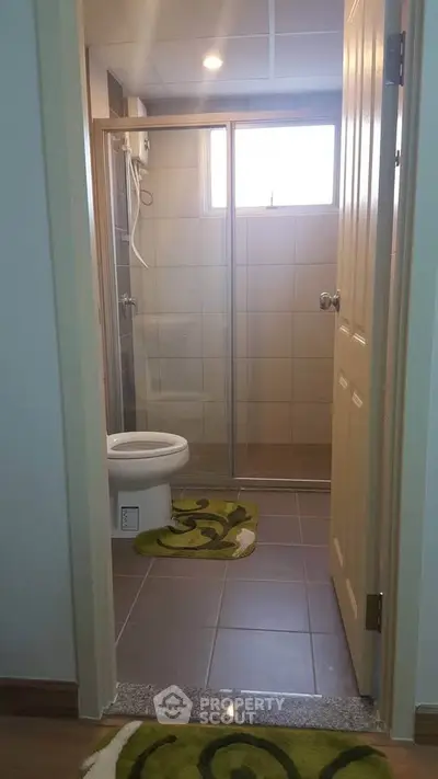 Modern bathroom with glass shower and stylish green rugs