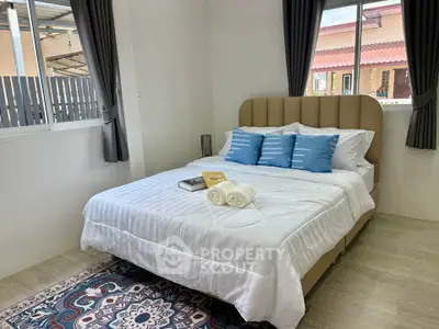 Cozy bedroom with stylish decor and natural light, perfect for relaxation and comfort.