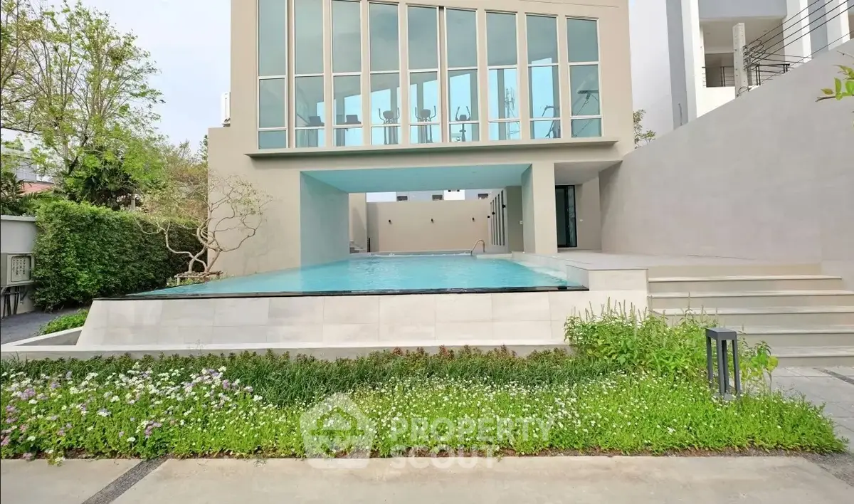 Luxurious modern building with stunning pool and lush garden