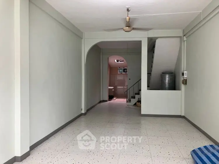 Spacious interior with tiled flooring and ceiling fan, ideal for versatile living space.