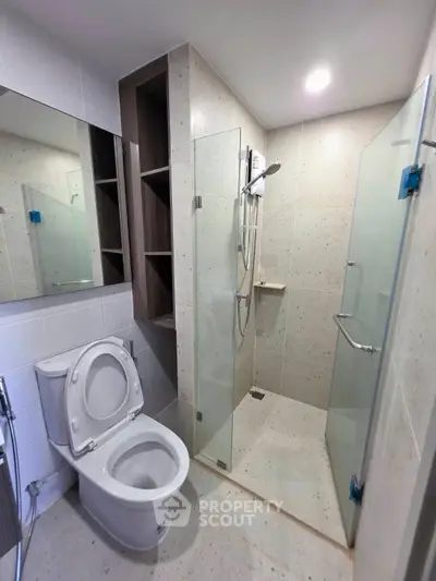 Modern bathroom with glass shower and sleek fixtures in a contemporary apartment.