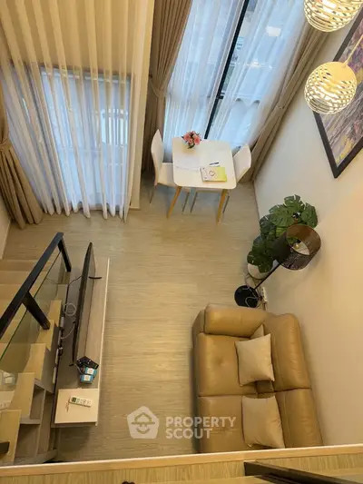 Modern living room with high ceiling, cozy sofa, and elegant decor in a stylish apartment.