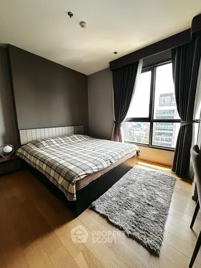 Modern bedroom with large window and city view, featuring stylish decor and cozy ambiance.