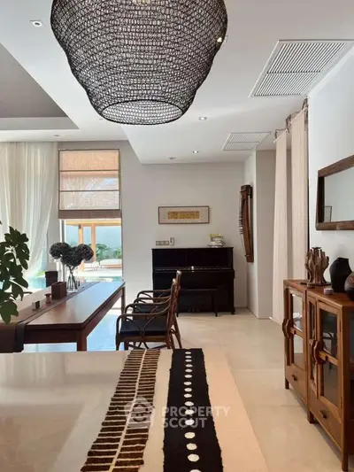 Luxurious living room with elegant decor and pool view, featuring stylish furniture and a grand piano.