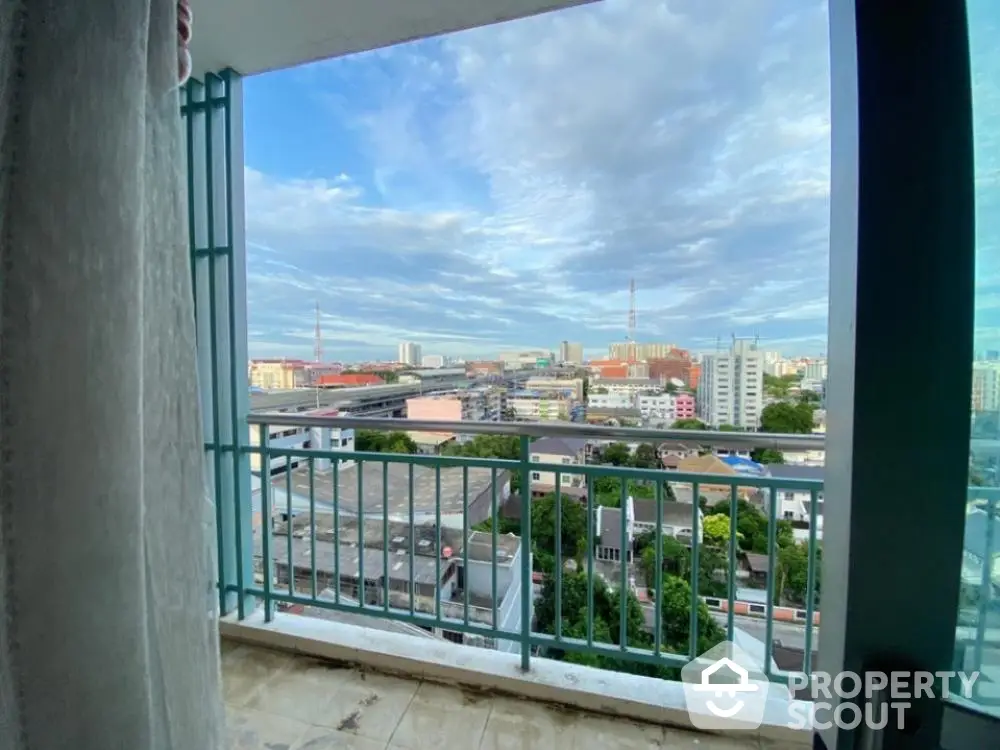 Expansive cityscape view from a high-rise balcony, showcasing a vibrant urban panorama under a dramatic cloudy sky, ideal for relaxation and entertainment.