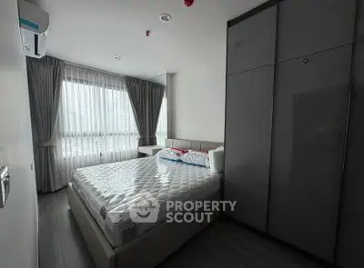 Modern bedroom with large window and sleek wardrobe in a stylish apartment.