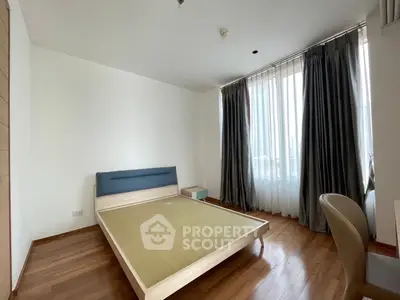 Spacious bedroom with modern design and large window offering natural light.