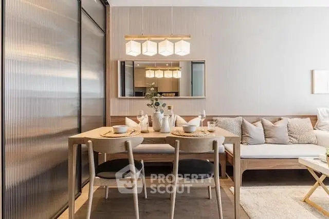 Elegantly furnished open-plan living space with a cozy dining area and modern kitchen, featuring warm lighting and tasteful decor.