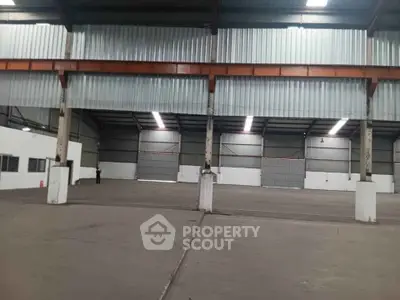 Spacious industrial warehouse interior with high ceilings and ample storage space.