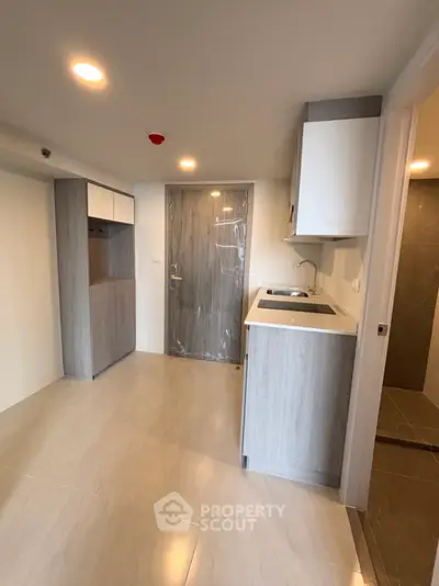 Modern compact kitchen with sleek cabinetry and integrated appliances in a stylish apartment.