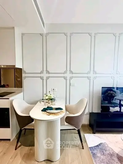 Modern dining area with elegant table and chairs, adjacent to a sleek kitchen and cozy living space.