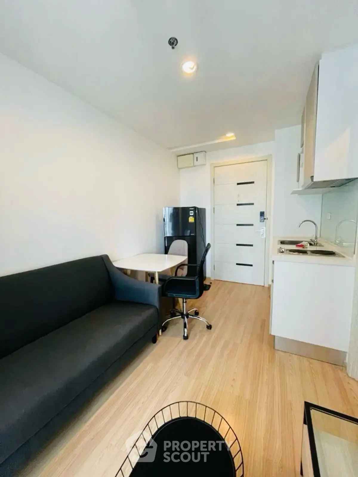 Modern compact living room with kitchenette and sleek furniture