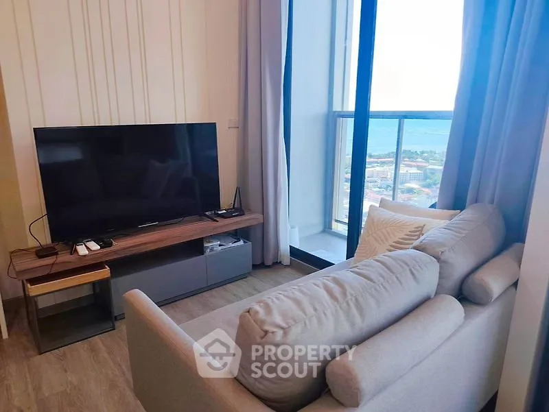 Modern living room with cozy sofa and stunning ocean view from balcony.