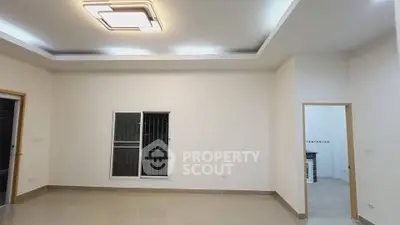 Spacious modern living room with sleek lighting and tiled flooring.