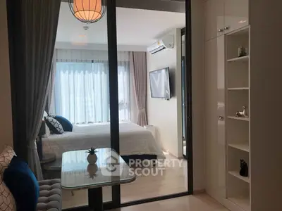 Modern bedroom with glass partition and stylish decor in a contemporary apartment.