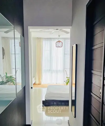 Bright and airy bedroom with large windows and modern decor, perfect for relaxation.
