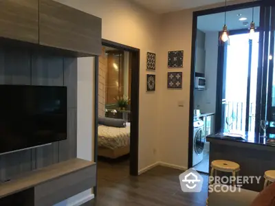 Modern apartment interior with open layout, featuring a cozy living room, stylish kitchen, and a glimpse of the bedroom.