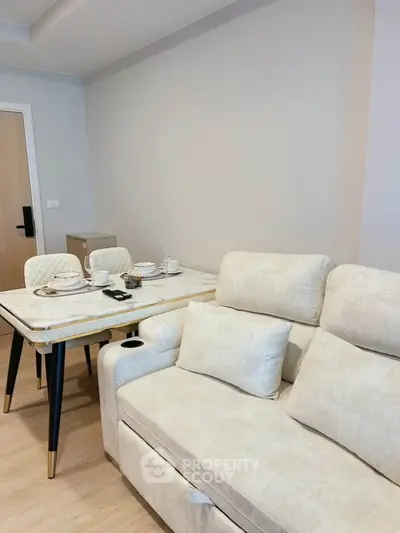 Modern living room with elegant beige sofa and stylish dining table set.
