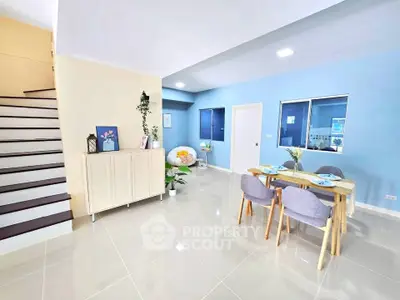 Modern open-plan living area with stylish dining set and staircase