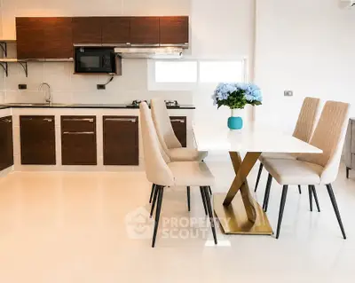 Modern kitchen with sleek cabinets and elegant dining area featuring a stylish table and chairs.